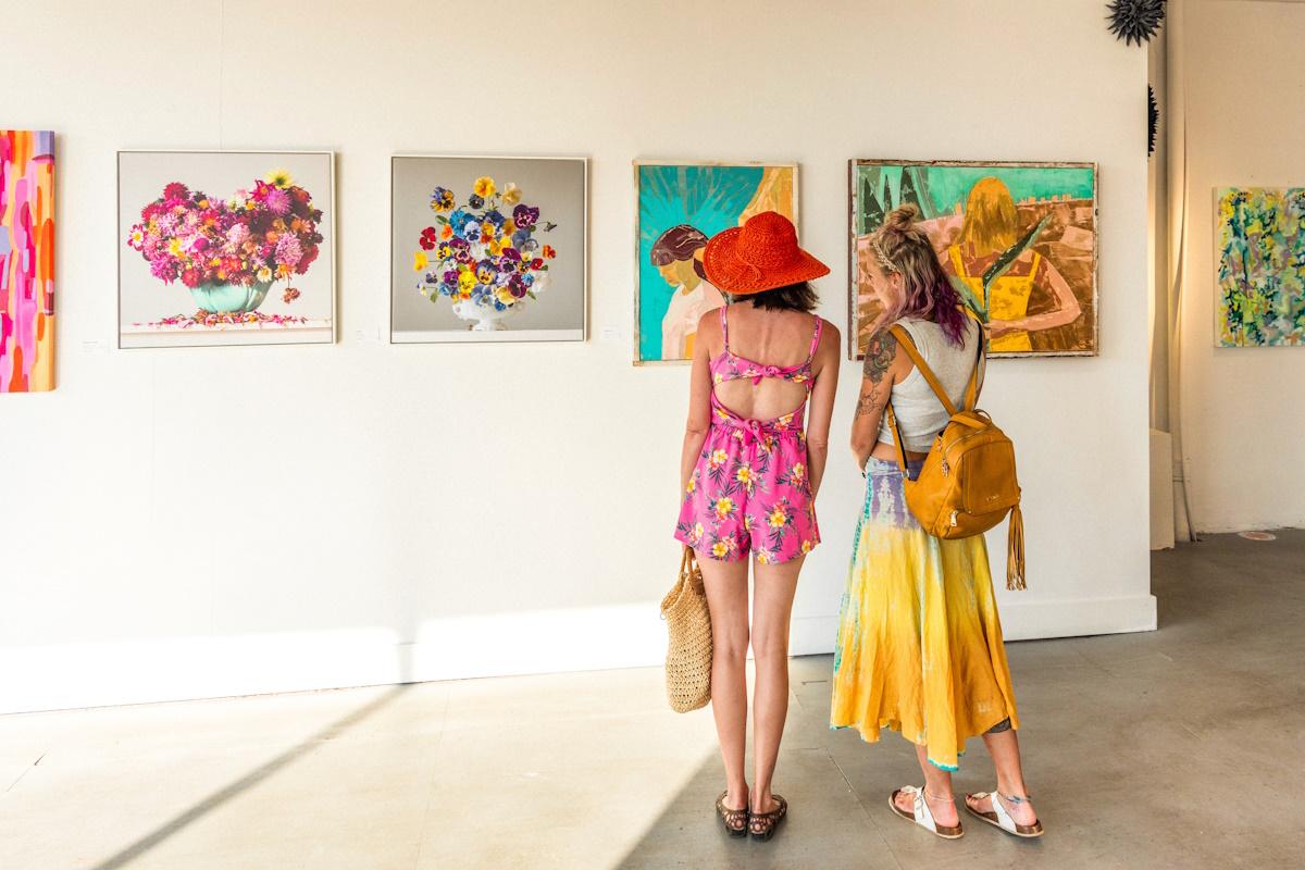 a pair of young women in colorful outfits looking at art in the ARS gallery in benton harbor