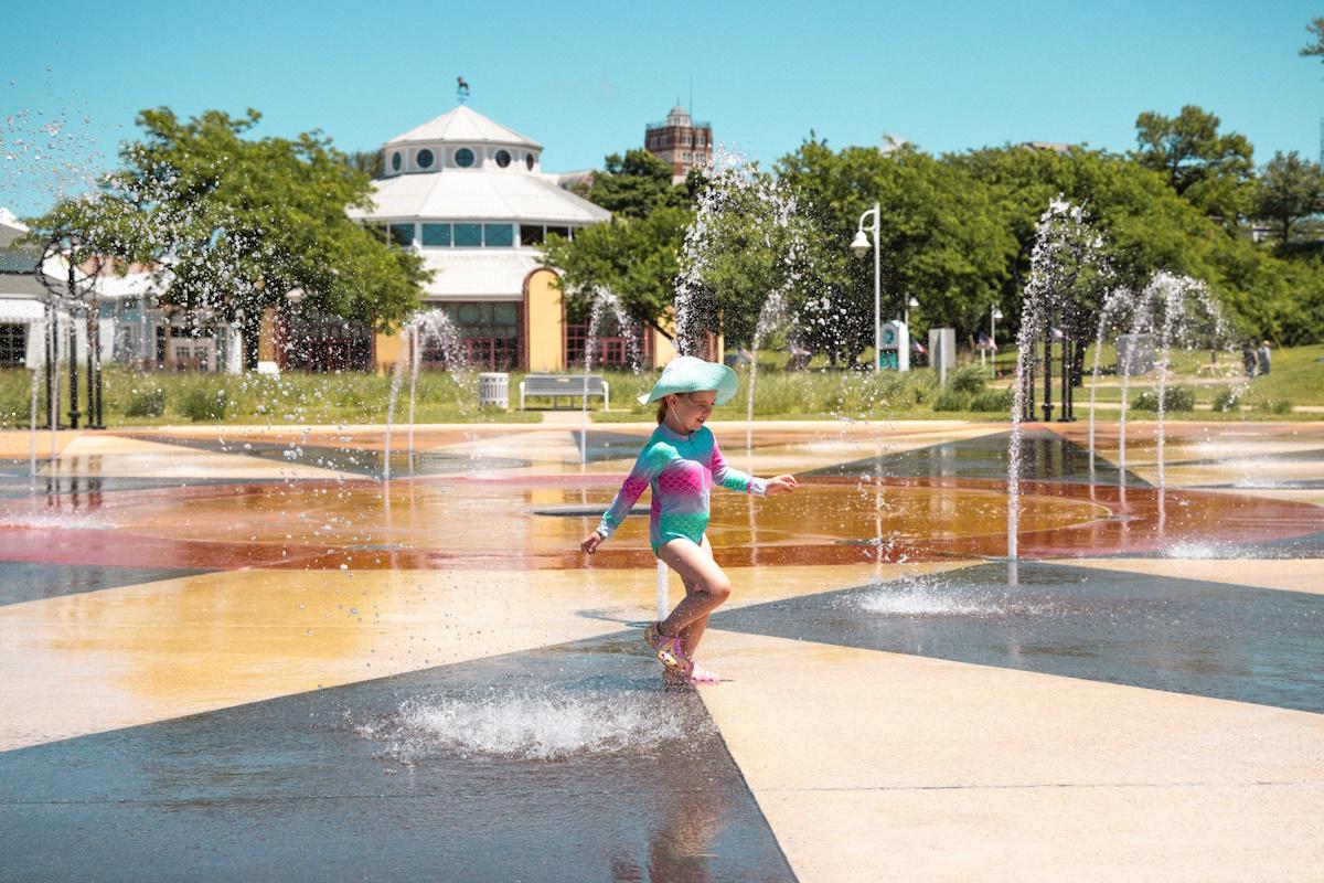 a young female child playing at the whirlpool compass fountain