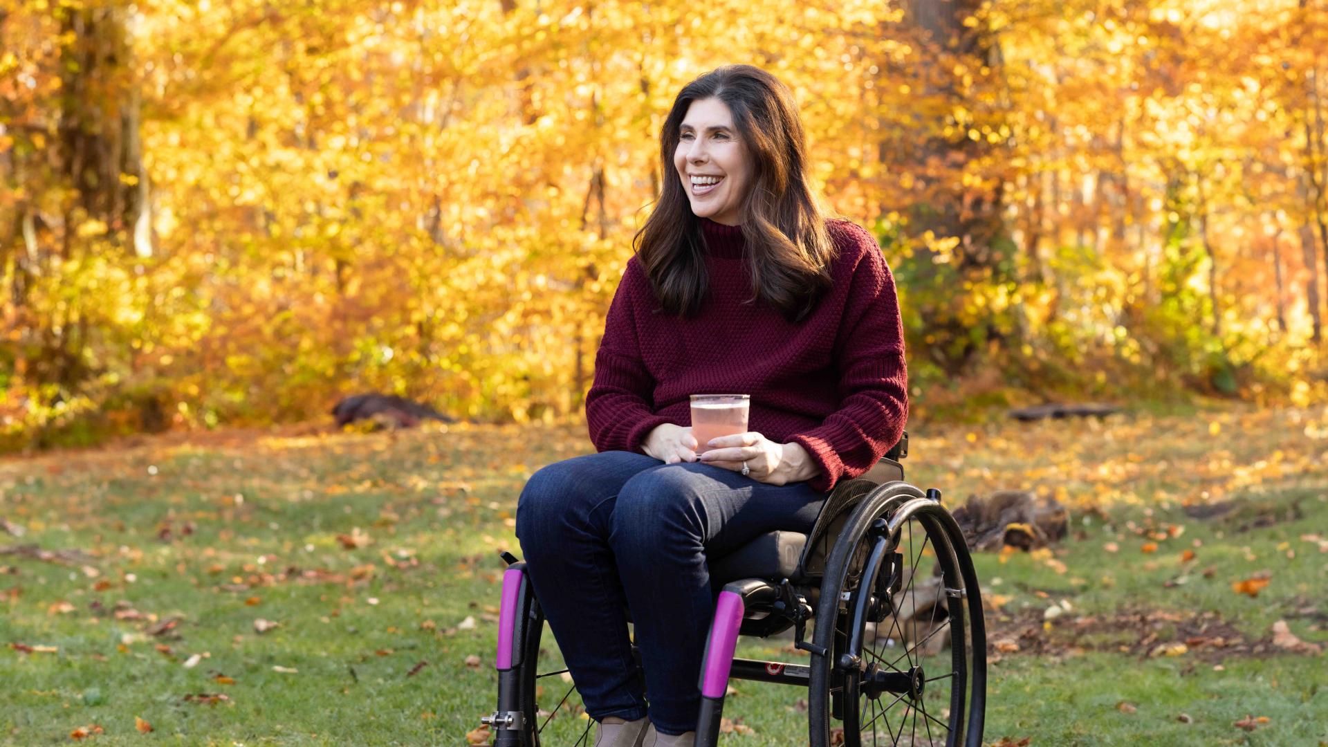 woman in a wheelchair enjoying drink outside