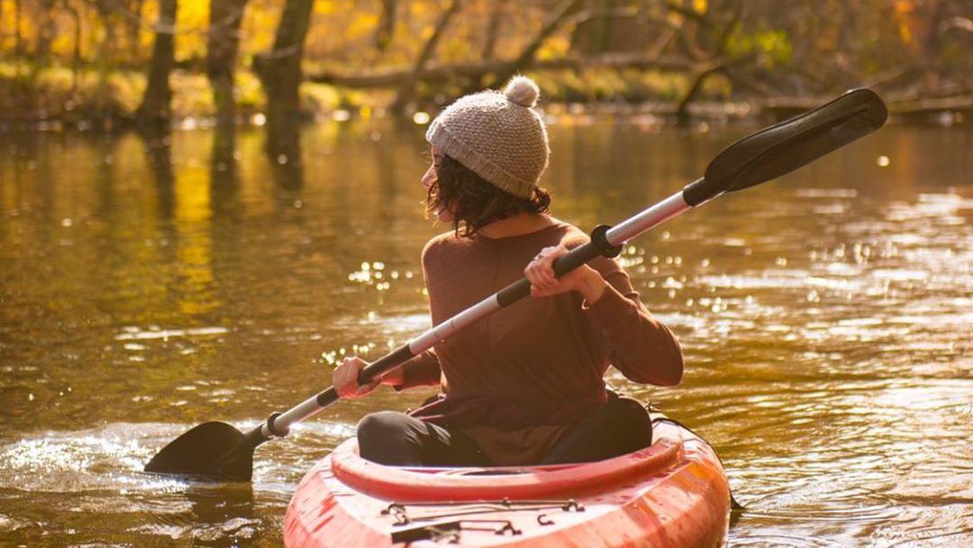 woman kayaking in fall