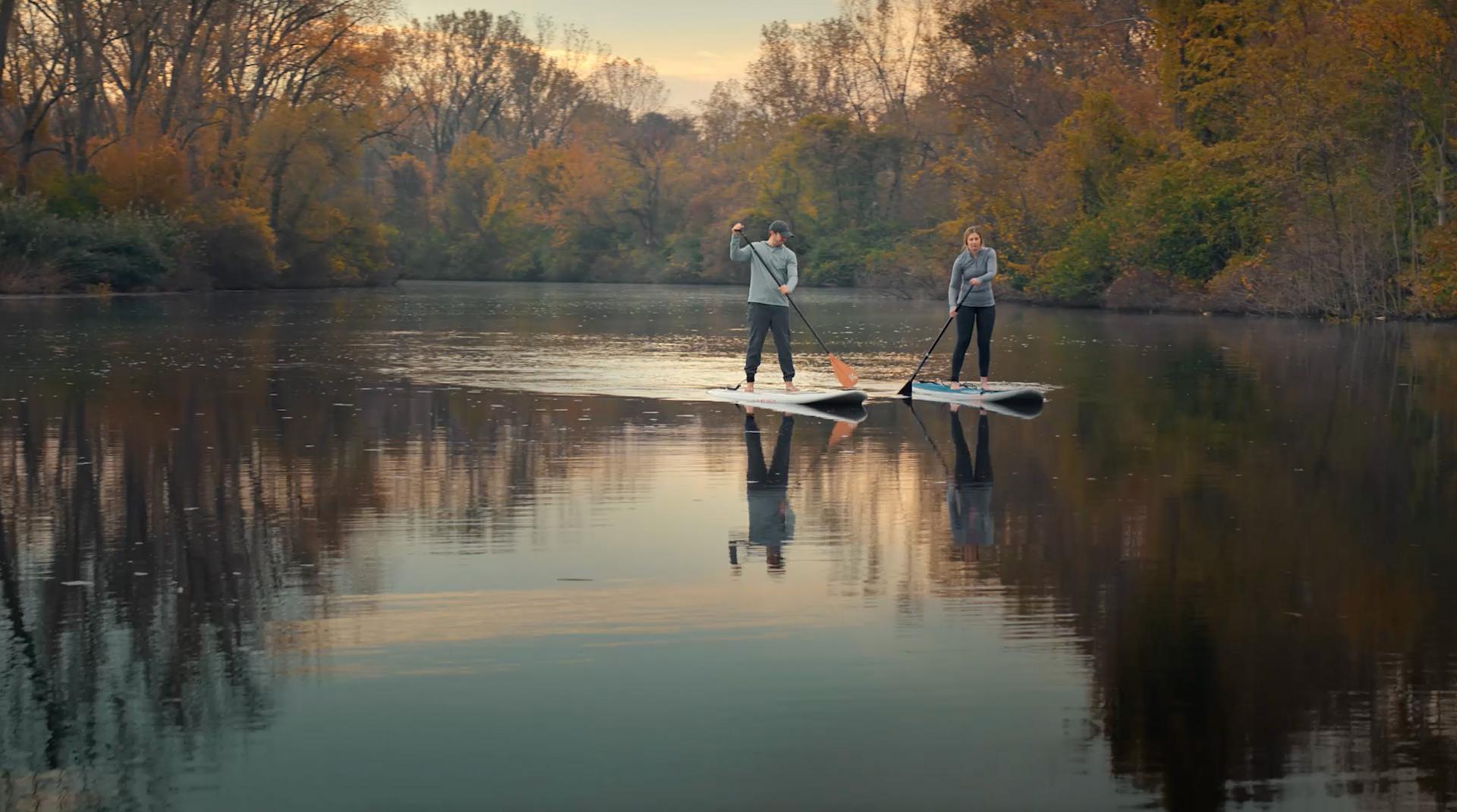 fall boarding couple standing on paddle boards on 