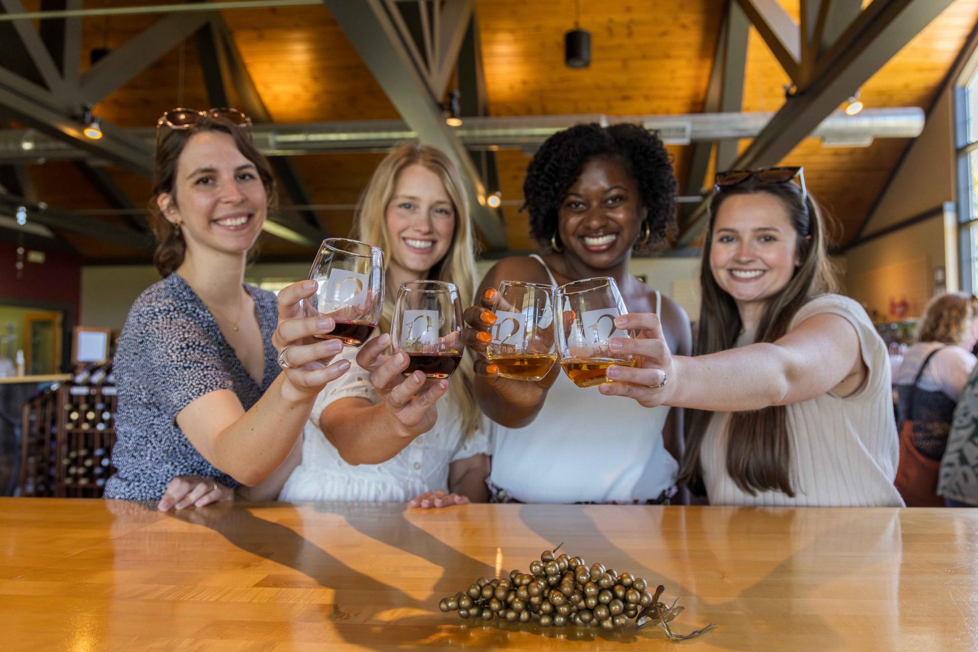 4 women toasting glasses at 12 Corners Vineyard