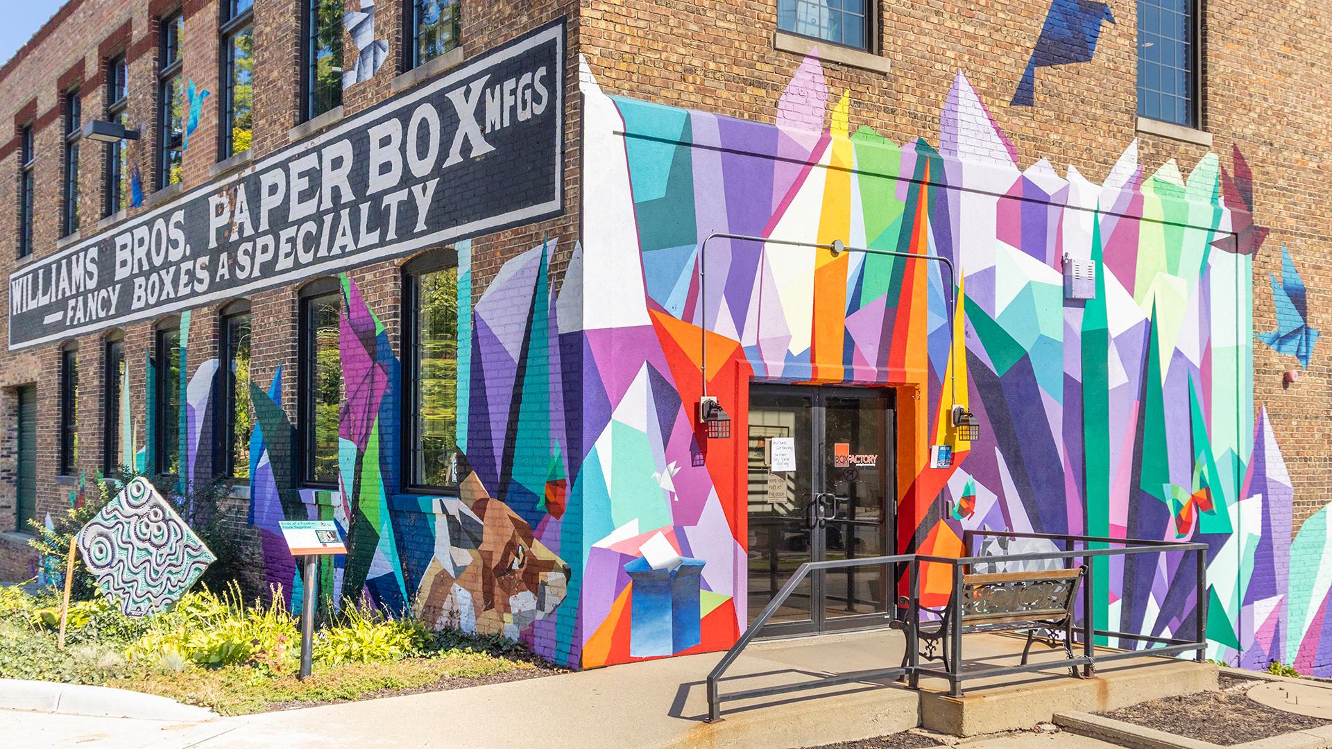 The exterior of the Box Factory for the Arts, featuring a colorful abstract-shaped mural pa_F5HH