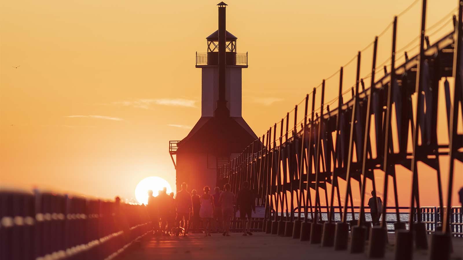 People walking the north pier in St. Joseph on a summer evening. 