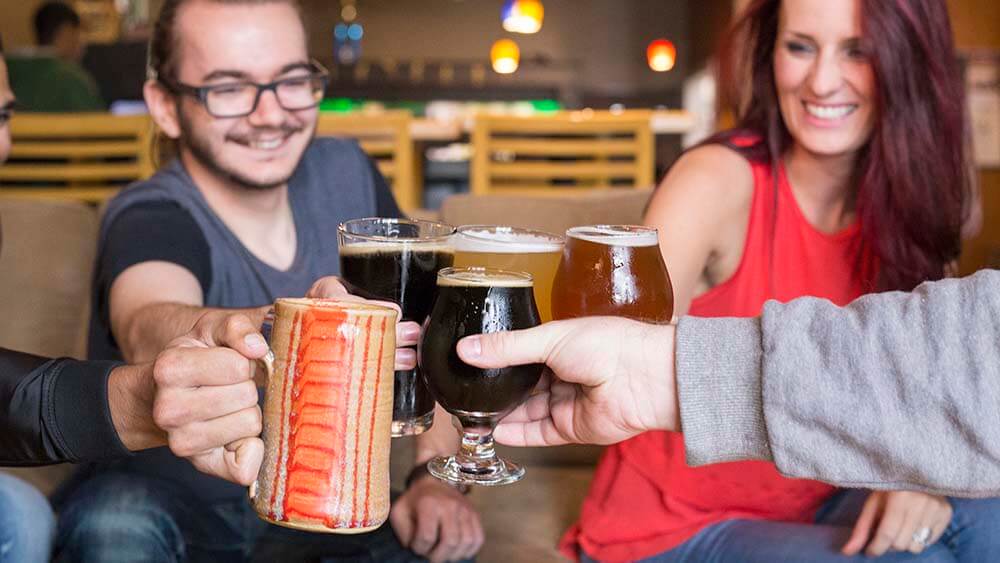 A group of people holding beers at Tapistry Brewing