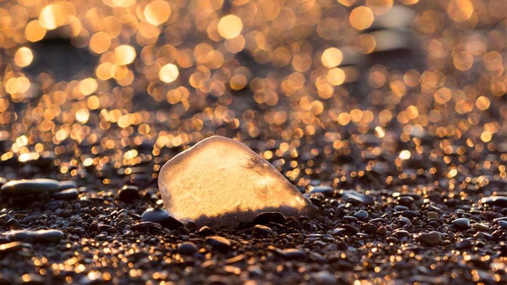 Beach glass and stones at sunset photo Joshua Nowicki