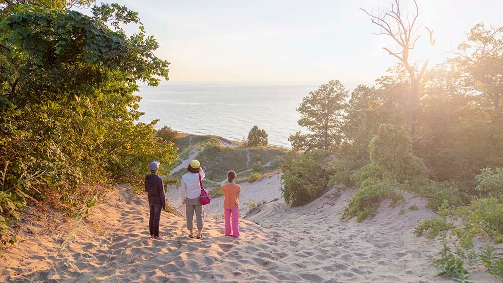 People enjoying the view from a dune at Grand Mere State Park