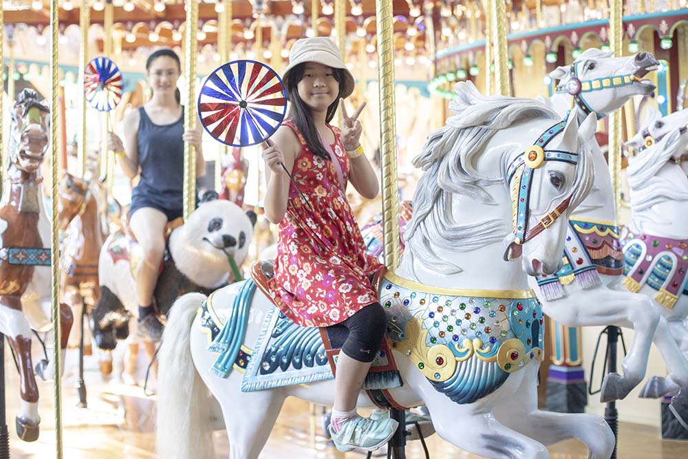 Two people riding on the carousel