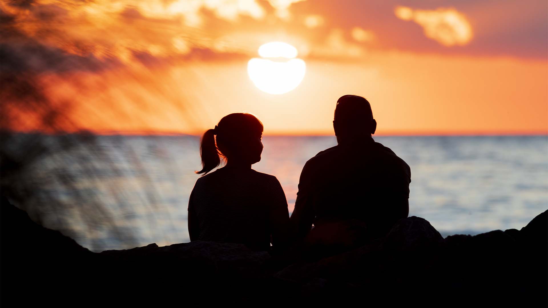 A couple enjoying the sunset at a beach.