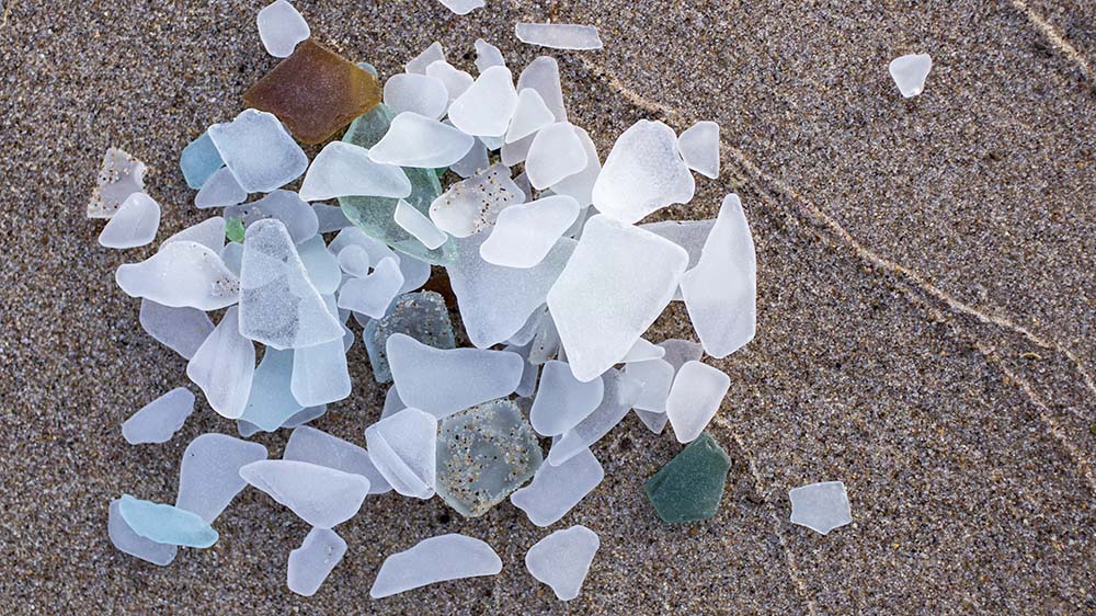 A pile of beach glass on the sand.