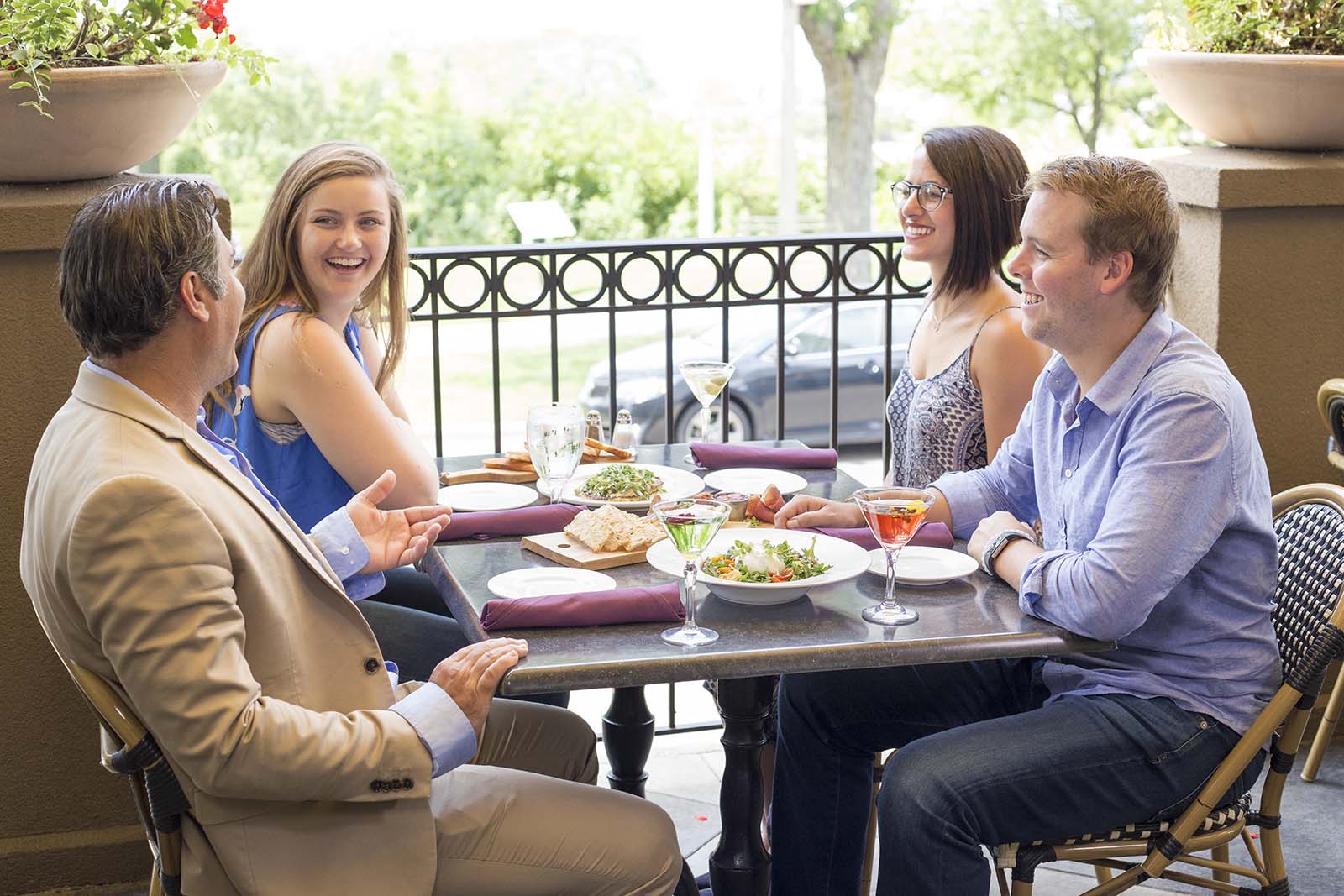 Four people dining outdoors at the Bistro