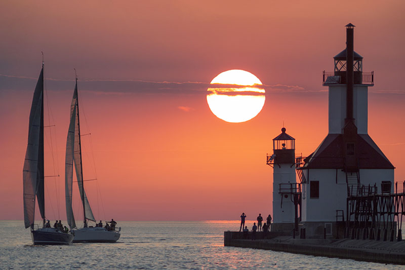 Lighthouse with Sailboats photo by Nowicki