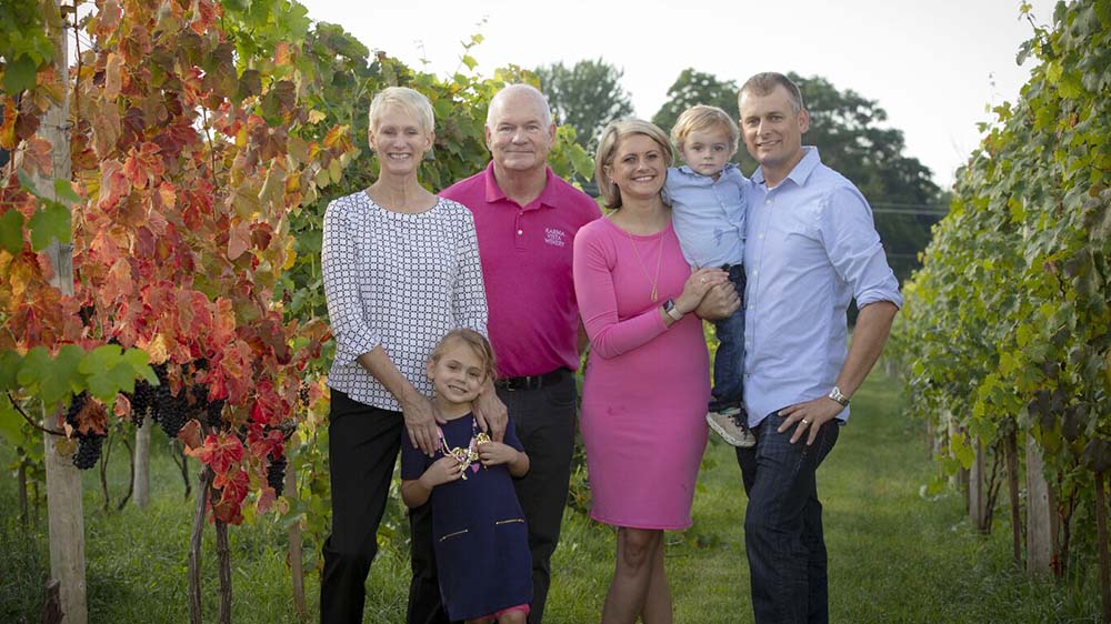 a family standing in a vineyard