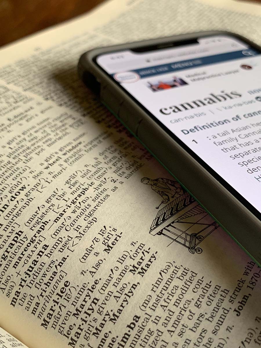 photo of a online and paper dictionary with the term cannabis open