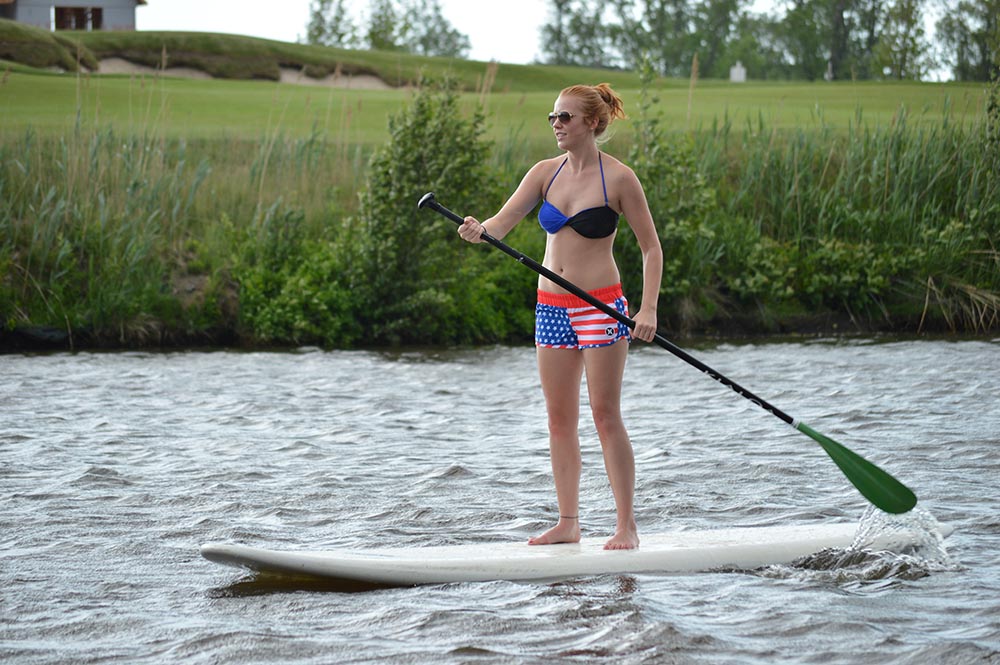 Woman paddle boarding along the St. Joseph river.